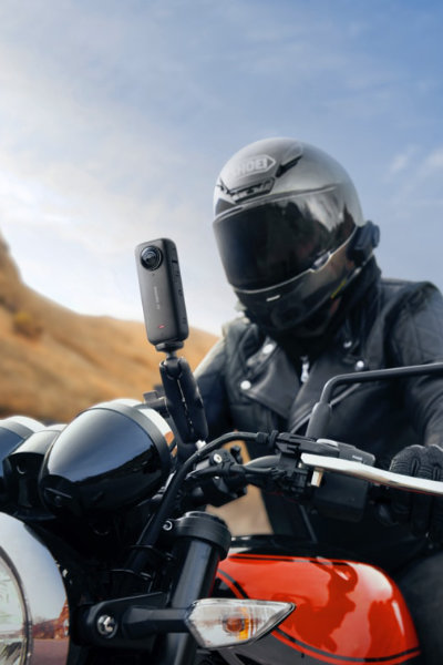 The Insta360 X3 Waterproof Action Camera attached to motorcycle handlebars with a motorcyclist sitting behind.